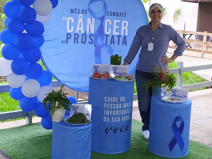 Cristina Selicani Sundfeld em estande com balões azuis na ação Novembro Azul